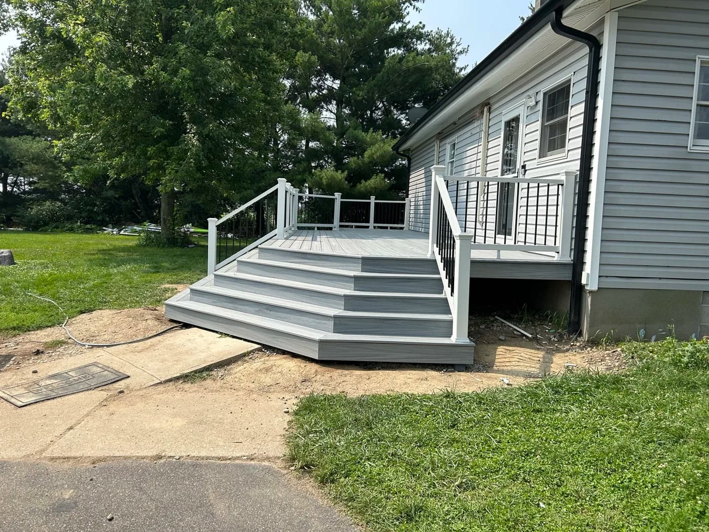 Gray composite deck with wide cascading steps and white railings