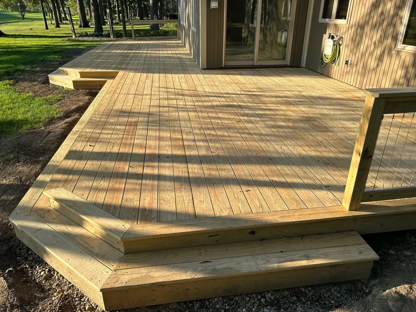 Timber-frame deck with wide steps on a wooded property